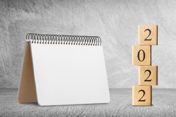 Sticker - 2022 concept with cubes on wooden table background, mockup calendar