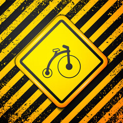 Wall Mural - Black Vintage bicycle with one big wheel and one small icon isolated on yellow background. Bike public transportation sign. Warning sign. Vector