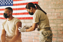 Army Doctor Administering The Covid-19 Vaccine To A Soldier