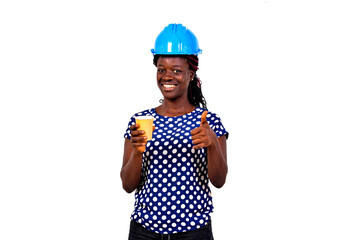 Wall Mural - beautiful young female engineer holding a cup of coffee and showing her thumb.