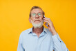 © Tatiana - old man gray beard with glasses talking on the phone isolated background