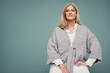 © Jacob Lund - Cheerful senior woman sitting against a studio background