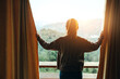 © oatawa - Woman opening curtains enjoy mountain view in morning, Happy traveller stay in hotel.
