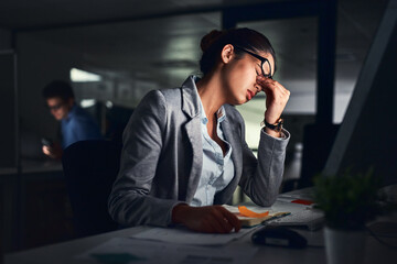 Poster - Its been a long day. Shot of a young attractive businesswoman working late at night in a modern office.