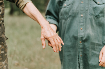 Wall Mural - happy senior couple holding hands. hands of man and woman hold each other. romance and love and support in elderly family. faceless husband and wife travel together in nature. people countryside life