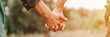 happy senior couple holding hands. hands of man and woman hold each other. romance and love and support in elderly family. husband and wife travel together in nature. countryside life. banner. flare