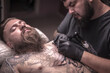 © Mr. Prof - Professional tattooer does tattoo on the skin of his client in tatoo salon