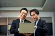 © bank215 - Asian Two Business men working with laptop in meeting room in office