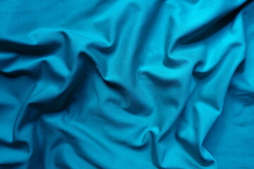 Texture of draped cerulean blue polyester fabric