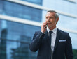 © Nikish Hiraman/peopleimages.com - Some fresh air and phone calls. Shot of a handsome mature businessman in corporate attire on a call outside during the day.