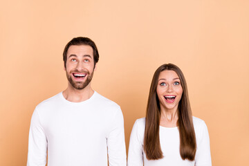 Poster - Portrait of attractive cheerful amazed trendy brown-haired spouses look up copy space wow isolated over beige pastel color background