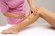 © Acronym - Beautician is removing hair from young female body and legs with hot wax. Woman has a beauty treament procedure. Depilation, epilation, skin and health care concepts.