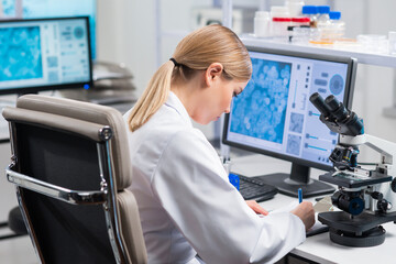 Wall Mural - Professional female scientist is working on a vaccine in a modern scientific research laboratory. Genetic engineer workplace. Future technology and science.