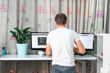 Man working on computer at standing desk at home office