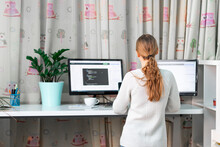 Young girl working on computer at standing desk at home office