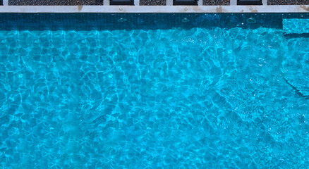 Wall Mural - Swimming pool blue water in summer top view angle. Aerial view images of swimming pool in a sunny day which suitable for sport or relax on vacation time or workout for burn some calories in holiday.