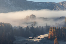 Two Alpine Huts On A Hill Of Seiser Alm Plateau Covered With Morning Mist And The First Frosts
