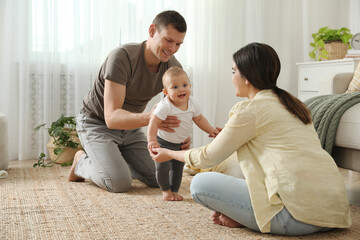 Sticker - Parents supporting their baby daughter while she learning to walk at home