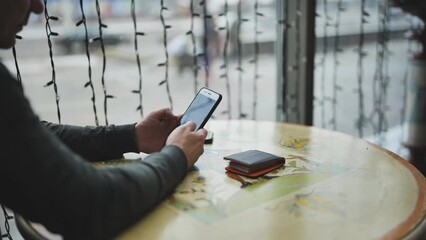 Silhouette of a man in a cafe writing a message on his smartphone on social media 4k