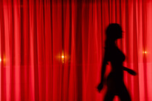 Anonymous Woman Walking Behind Curtain