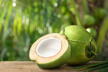 Wall Mural - Coconut juice in half fruit with coconut tree background.