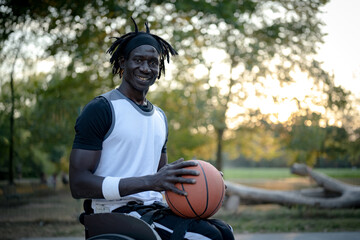 African man with a disability playing basketball on a wheelchair, portrait of smiling adult male champion athlete looking at the camera, concept of social inclusion, accessibility and diversity