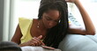 © Marco - Candid black girl using smartphone device, teen girl browsing social media