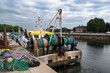 A fishing boat with its nets in a port in Normandy, France