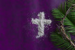 cross of ashes with border of palm fronds and crown of thorns on a dark purple background