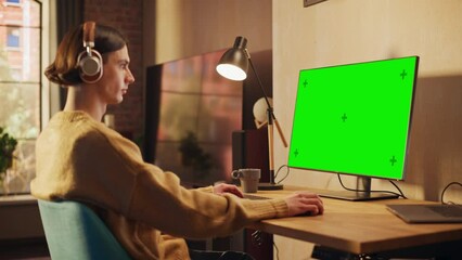 Poster - Young Handsome Man Working from Home on Desktop Computer with Green Screen Mock Up Display. Creative Male Checking Social Media, Browsing Internet. Urban City View from Big Window. Static Shot.