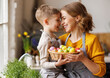 © JenkoAtaman - Sweet family portrait of young mother and little son with wicker basket full of painted Easter eggs