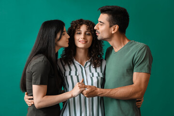 Wall Mural - Man and two beautiful women on color background. Polyamory concept