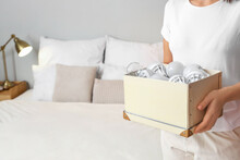 Woman Holding Box With Light Bulbs In Bedroom, Closeup