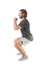 Sporty man doing squats on white background