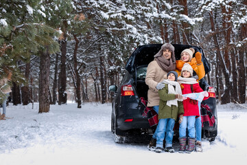 Poster - Happy family with car in forest on snowy winter day