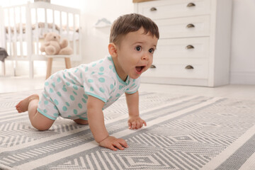 Cute baby crawling on floor at home