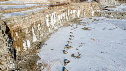 An empty rock quarry in winter that is abandoned during the cold winter season.