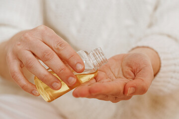 Canvas Print - A closeup shot of a female hand pouring oil