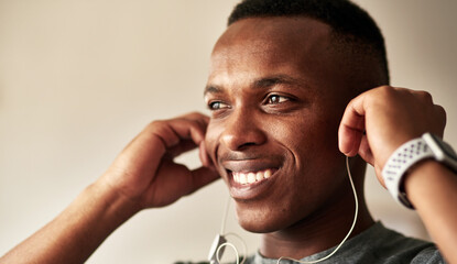 Canvas Print - No one motivates me like music does. Cropped shot of a handsome young man putting his earphones in his ears.