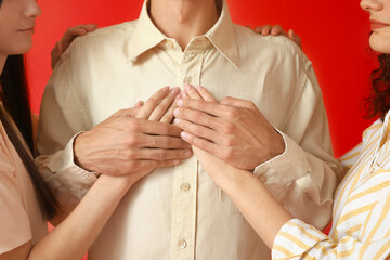 Wall Mural - Man and two beautiful women on color background. Polyamory concept