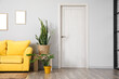 © Pixel-Shot - Wooden table with houseplants and yellow sofa near light wall