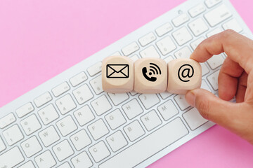 concept of contact us. hand grab wooden cube dice block with symbol email telephone address placed o