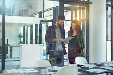 Poster - The online world is so dynamic. Cropped shot of colleagues working together on a digital tablet in a modern office.