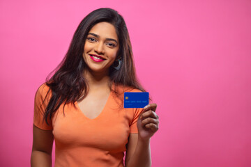 Wall Mural - Young woman showing credit card in front of camera with smile