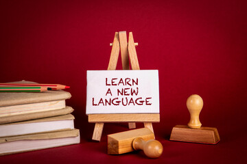 Wall Mural - Learn a New Language. Stack of books and stamps on a red background