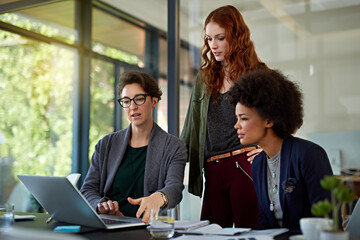 Poster - Their work is built on excellence. Cropped shot of colleagues working together on a laptop in a modern office.