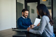 © bnenin - Smiling caucasian man, reading a document his coworker brought him.