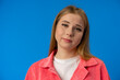 © fotofabrika - Young woman looking at you with suspicion and accusing over blue background