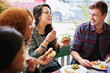 © Marius Venter/peopleimages.com - Fast food and friendship. Cropped shot of a group of friends eating burgers outdoors.