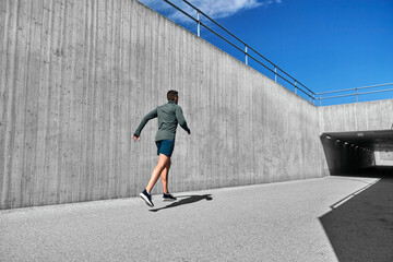 Wall Mural - fitness, sport and healthy lifestyle concept - young man running out of tunnel